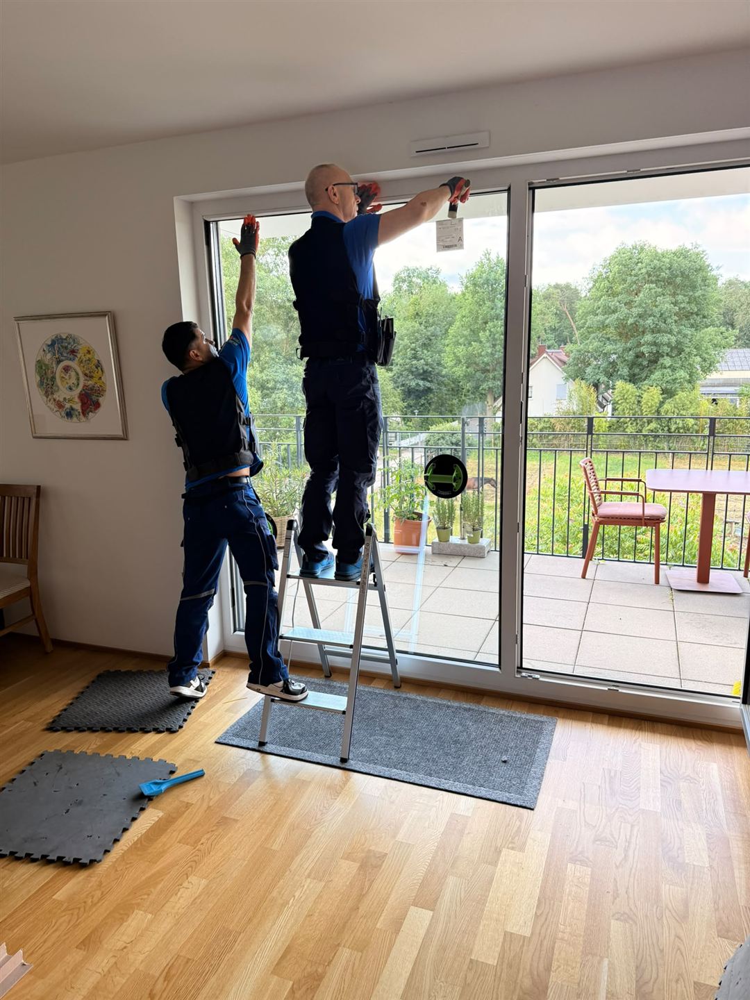 Zwei FensterFix-Techniker prüfen einen Fensterflügel